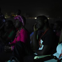 Slam artists listening to each other at a concert.