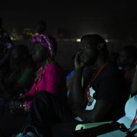 Slam artists listening to each other at a concert.